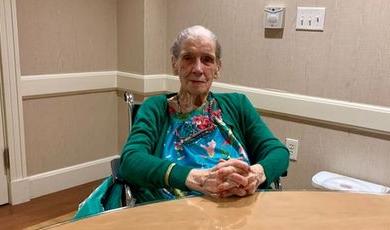 Ruth Calhoun poses for a photo sitting at a table.