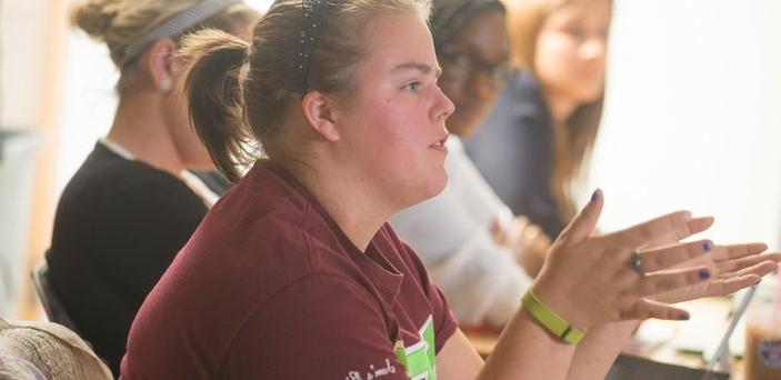 Student in classroom asking a question