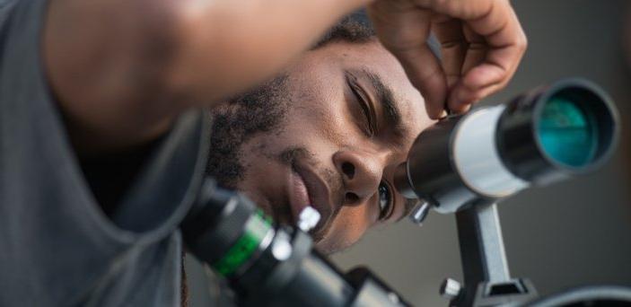 A student looking through a telescope