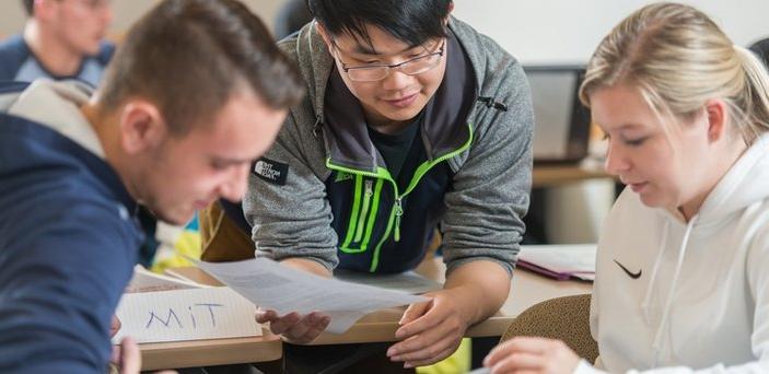 Three students doing group work in class