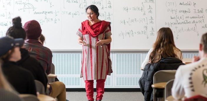 Professor Uma Shama teaching a class standing in front of a white board that outlines the Fundamental Theorem of Calculus