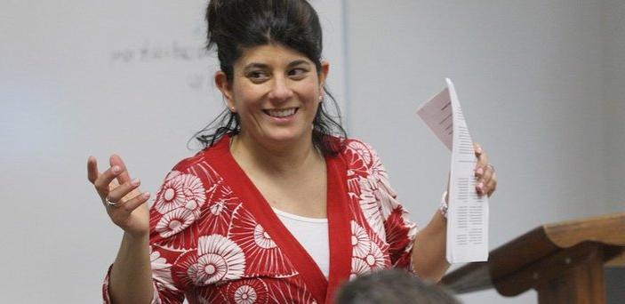 Professor Sarah Thomas teaching a class and smiling