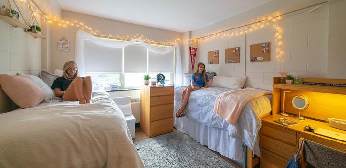 Two students study on their beds