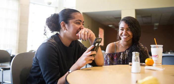 Friends laugh with each other during lunch